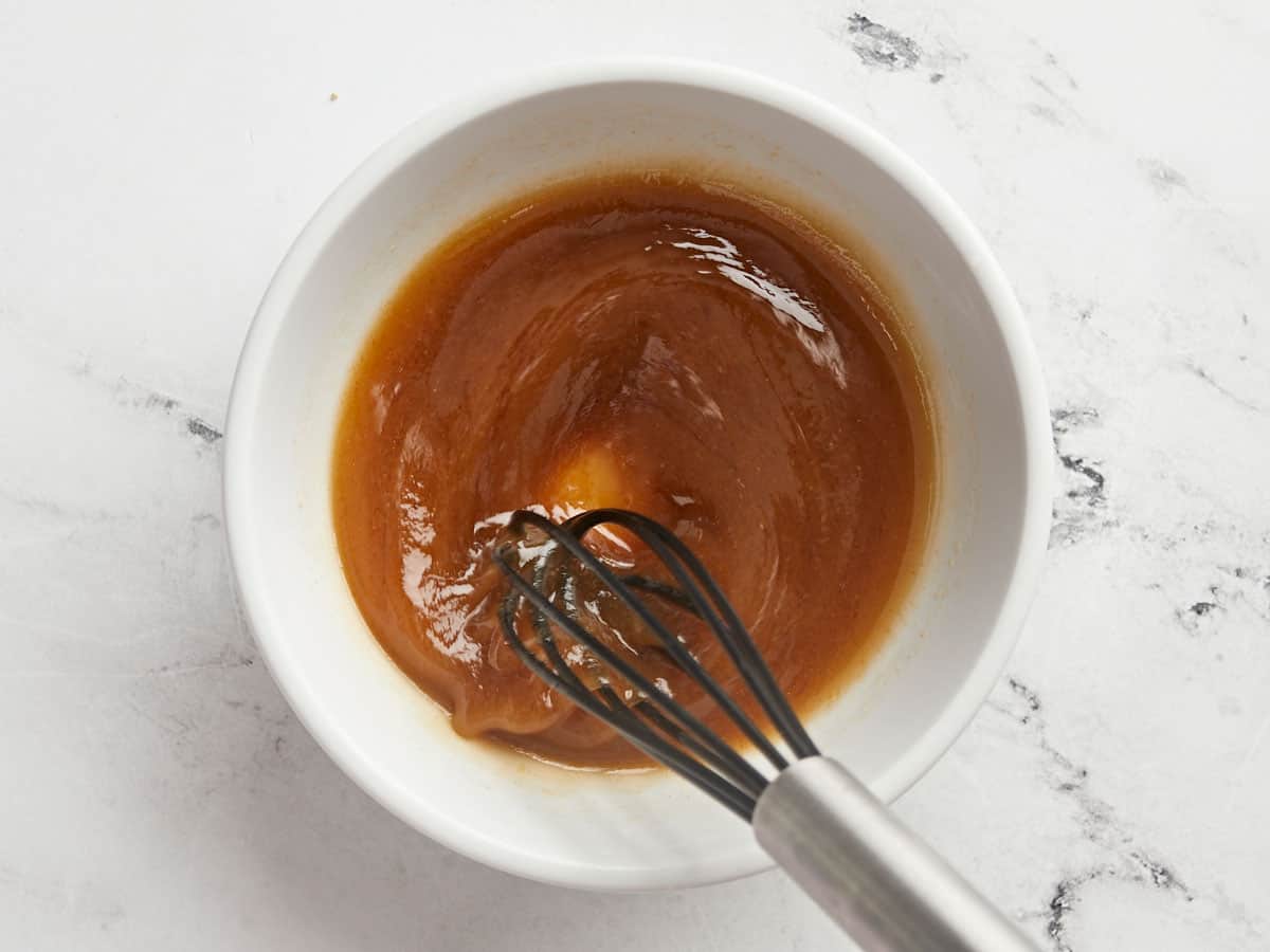 Sesame dressing being whisked in a bowl. 