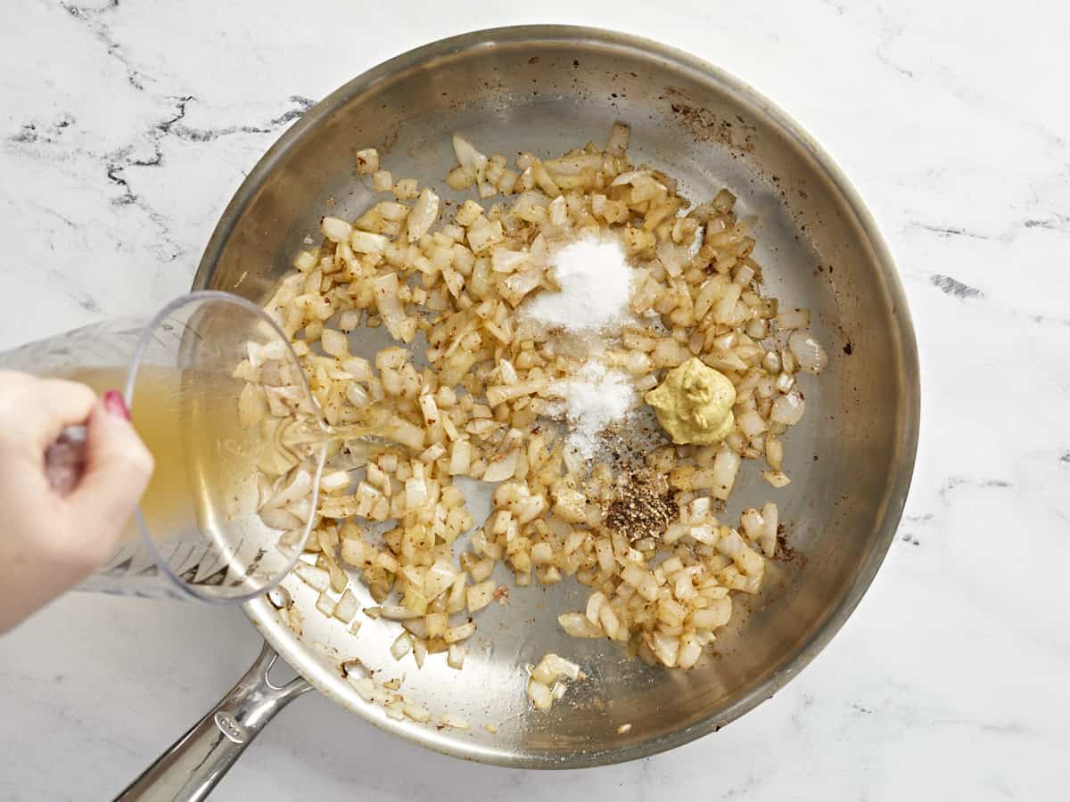 Dressing ingredients added to the skillet with the onions