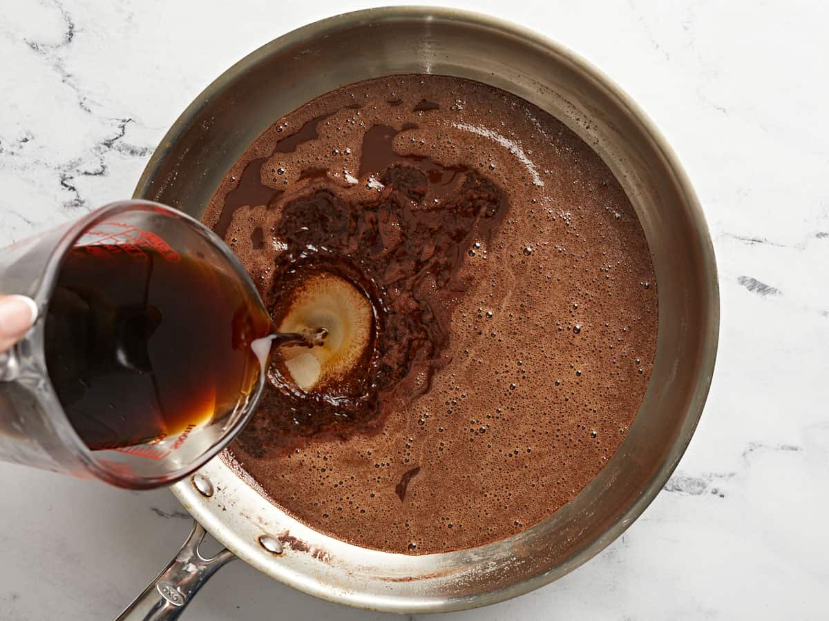 Coffee being added to the skillet with the chocolate.