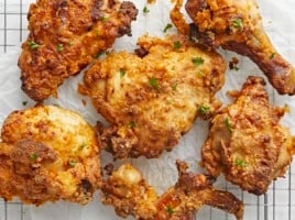 Overhead close up view of Air Fryer Fried Chicken on parchment paper and a cooling rack.