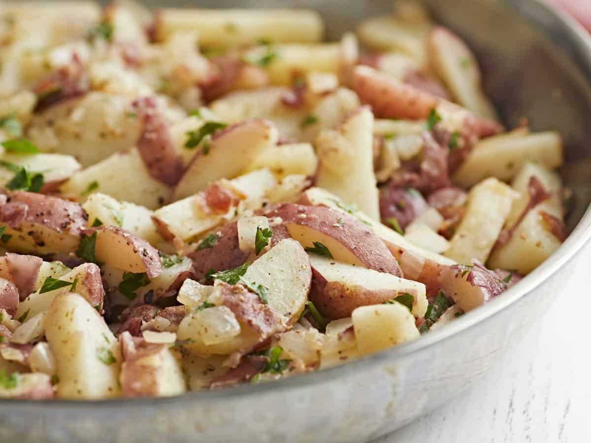 Close up side view of German potato salad in the skillet.