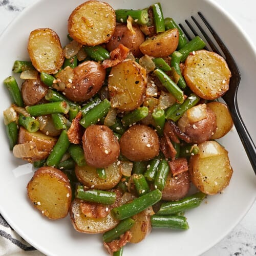 Close up overhead view of a bowl of potatoes and green beans.