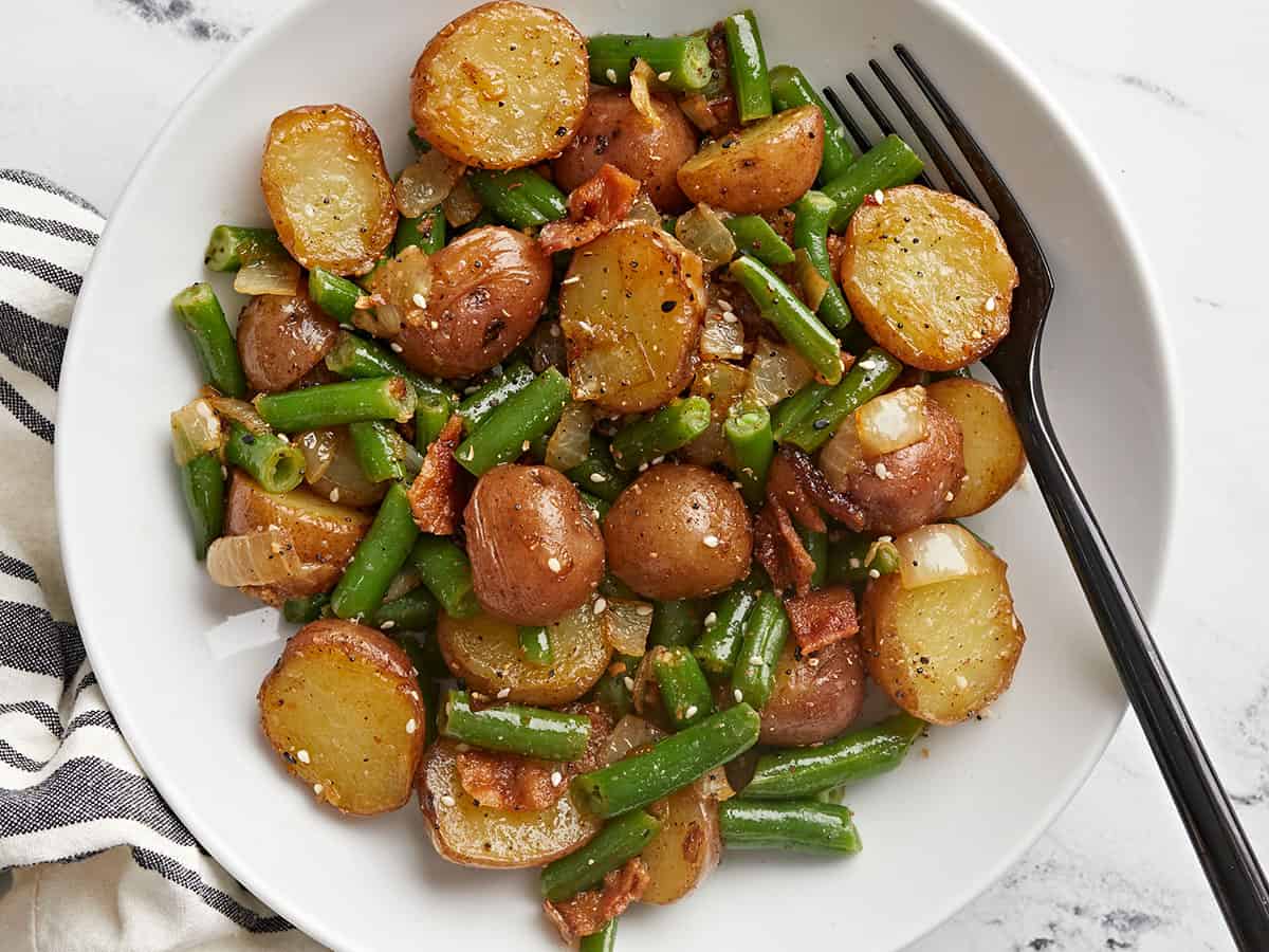 Close up overhead view of a bowl of potatoes and green beans.