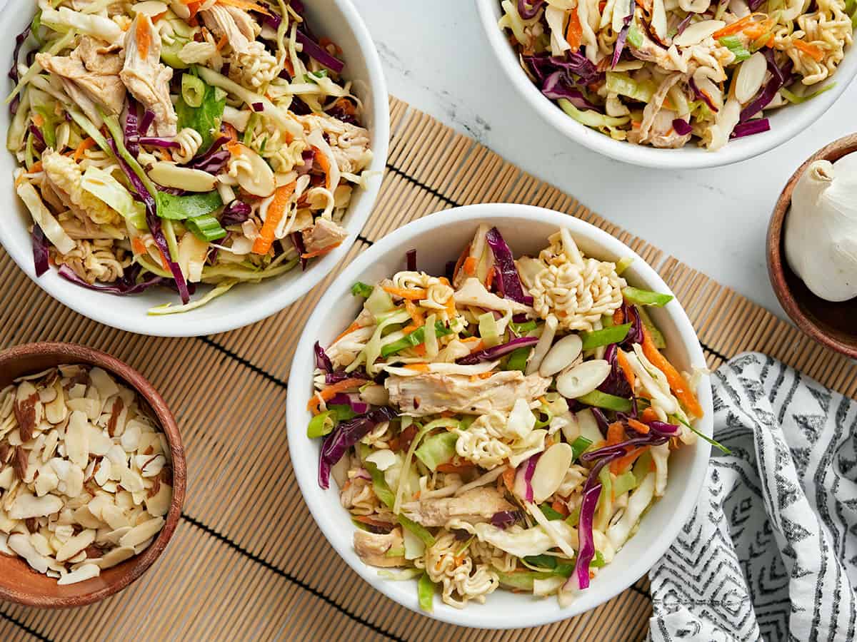 Overhead view of three bowls of ramen noodle salad.