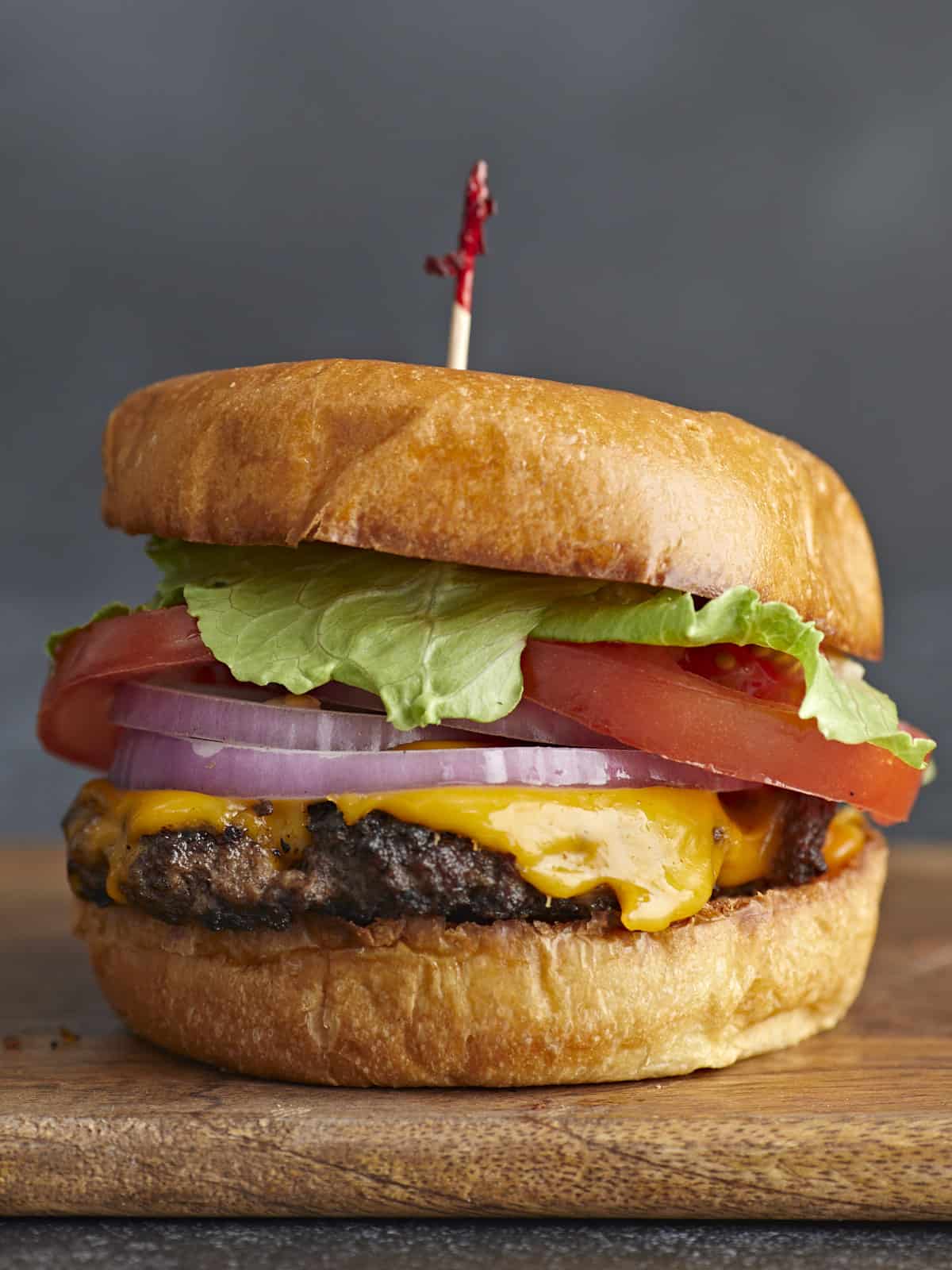 Side shot of a Smash Burger with a toothpick in the bun.