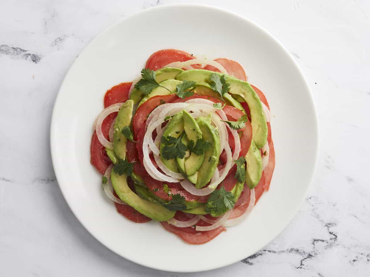 Overhead shot of finished Ensalada de Aguacate on a white plate.