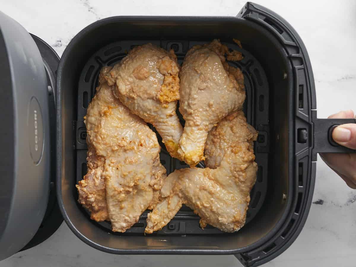 Overhead shot of battered chicken placed in an air fryer.