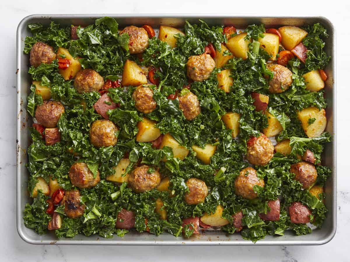 Overhead shot of kale being placed in the sheet pan.