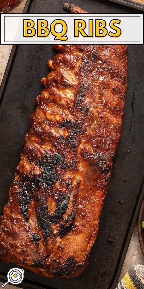 Baked ribs on a black plater.