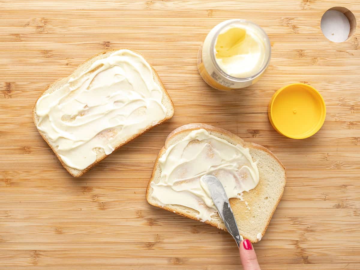 Mayonnaise being spread onto bread.