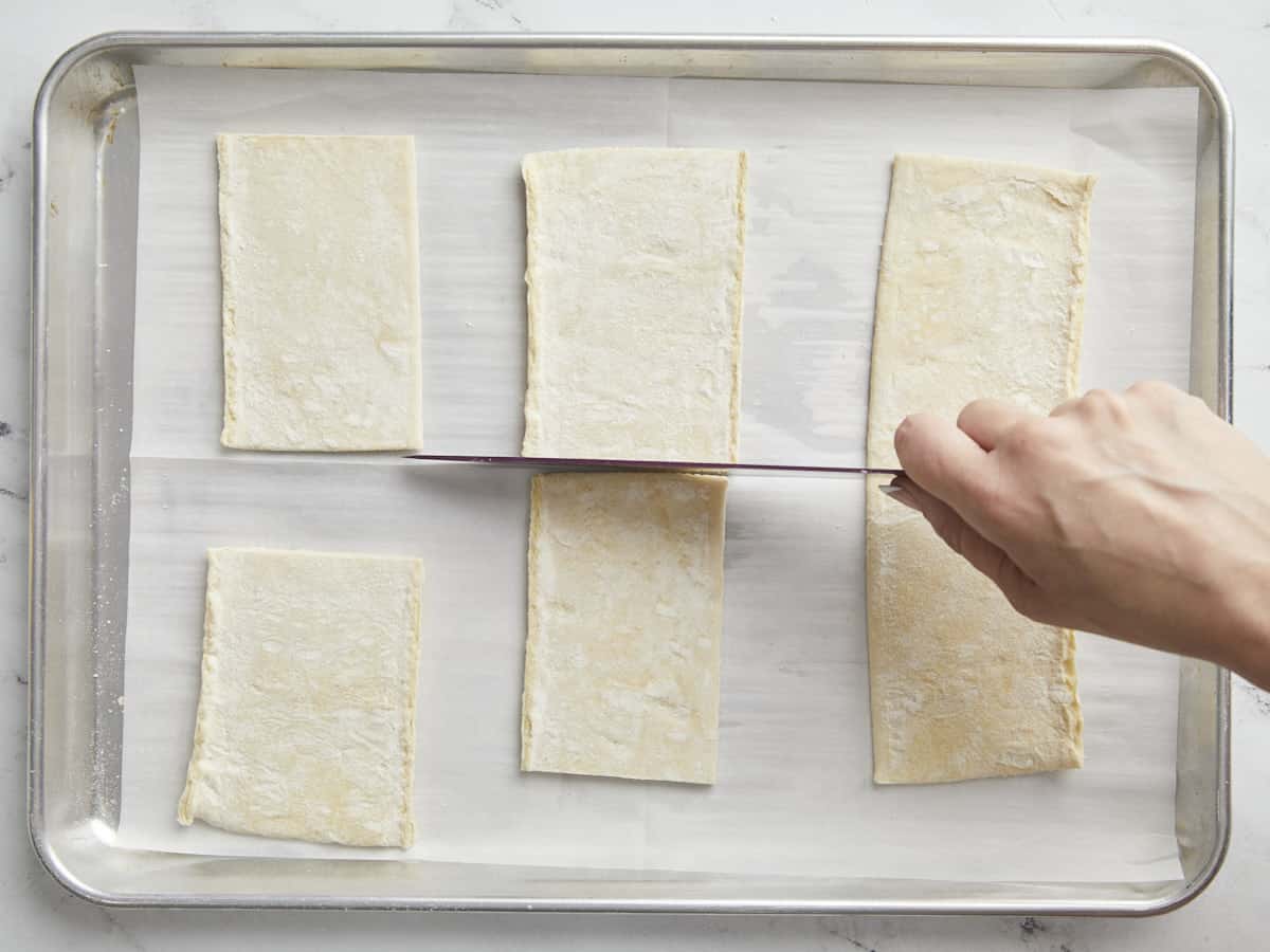 Overhead shot of sheet of puff pastry cut into six rectangles.