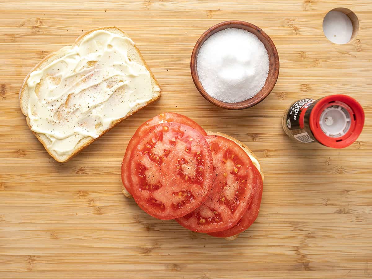 Tomato slices on the bread with salt and pepper.