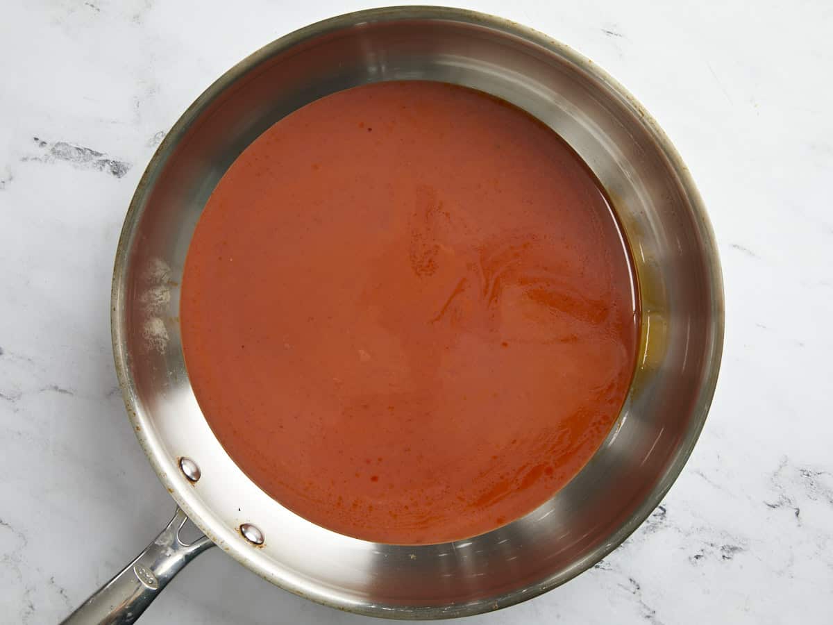 Overhead shot of red sauce "salsa roja" in a silver sauce pan.