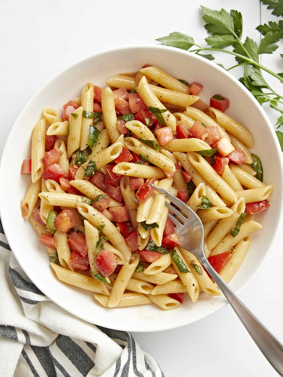 Overhead view of a bowl full of Bruschetta Pasta with a fork in the center.