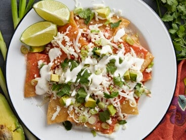 Overhead shot of chilaquiles served on a white plate.