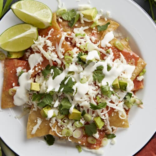 Overhead shot of chilaquiles served on a white plate.