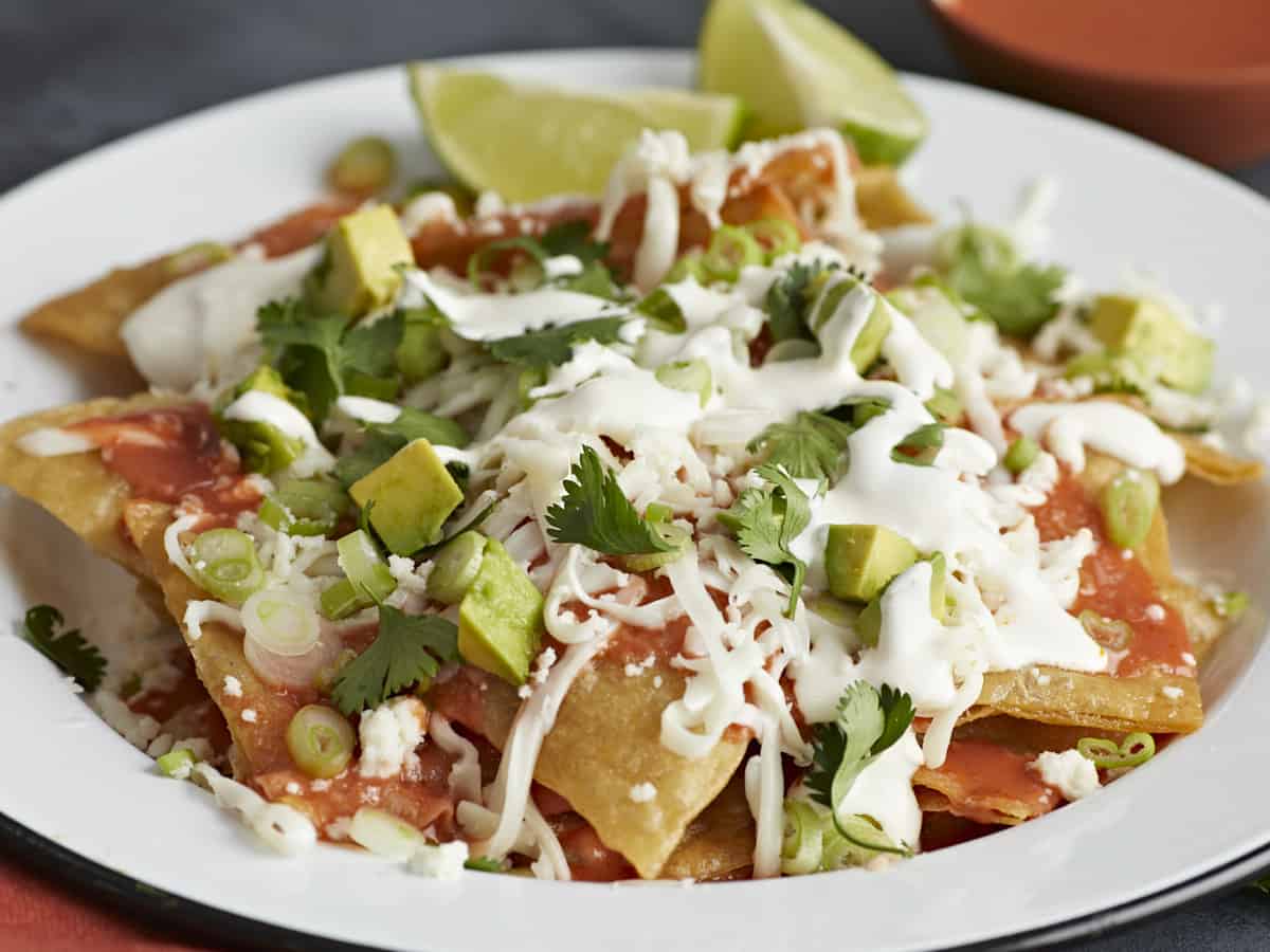 Side shot of chilaquiles served on a white plate.