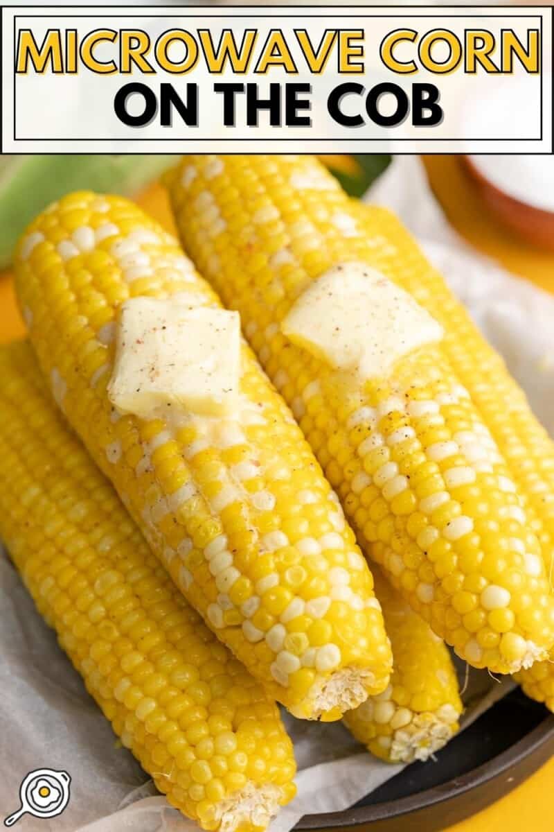 Overhead shot of corn on the 4 cobs of Microwave Corn On The Cob on a black plate with two pats of butter melting on top.