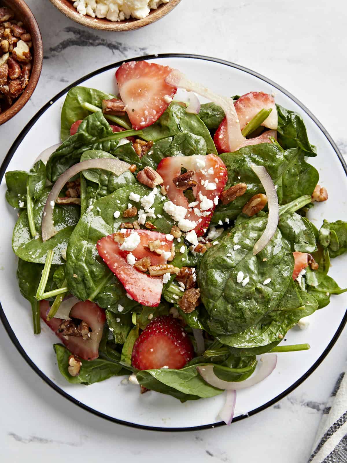 Close up overhead shot of plated strawberry spinach salad.