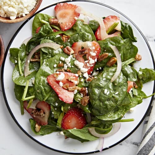 Overhead close up shot of plated strawberry spinach salad.