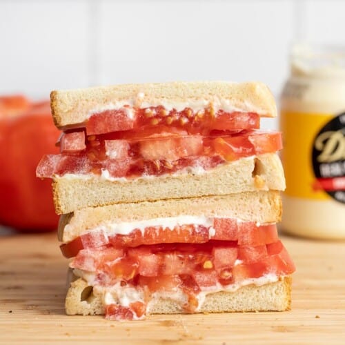 Side view of a sliced and stacked tomato sandwich.