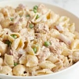 Close up side view of a bowl full of tuna pasta salad.