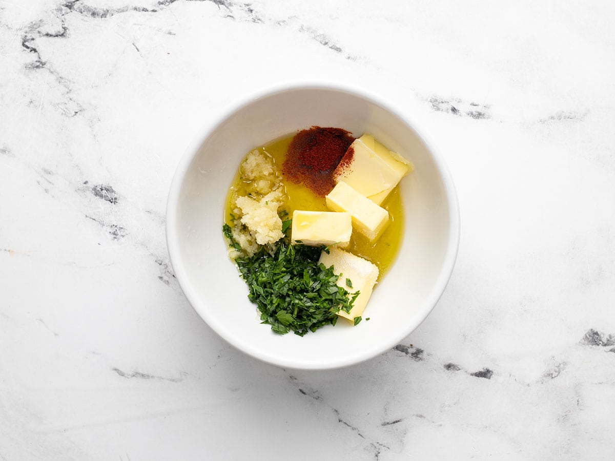 Ingredients for garlic butter in a bowl, not mixed.