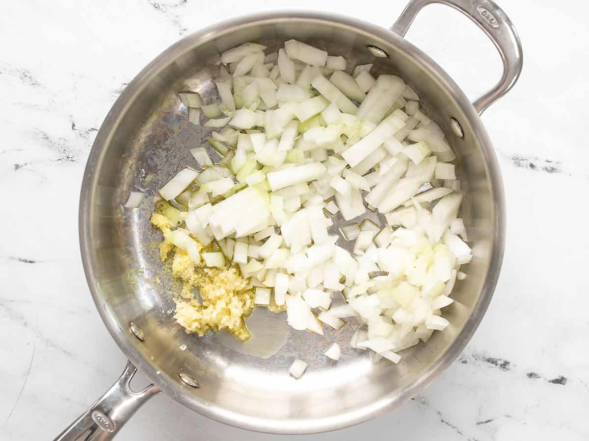 Diced onion, minced garlic, and grated ginger in a deep skillet.