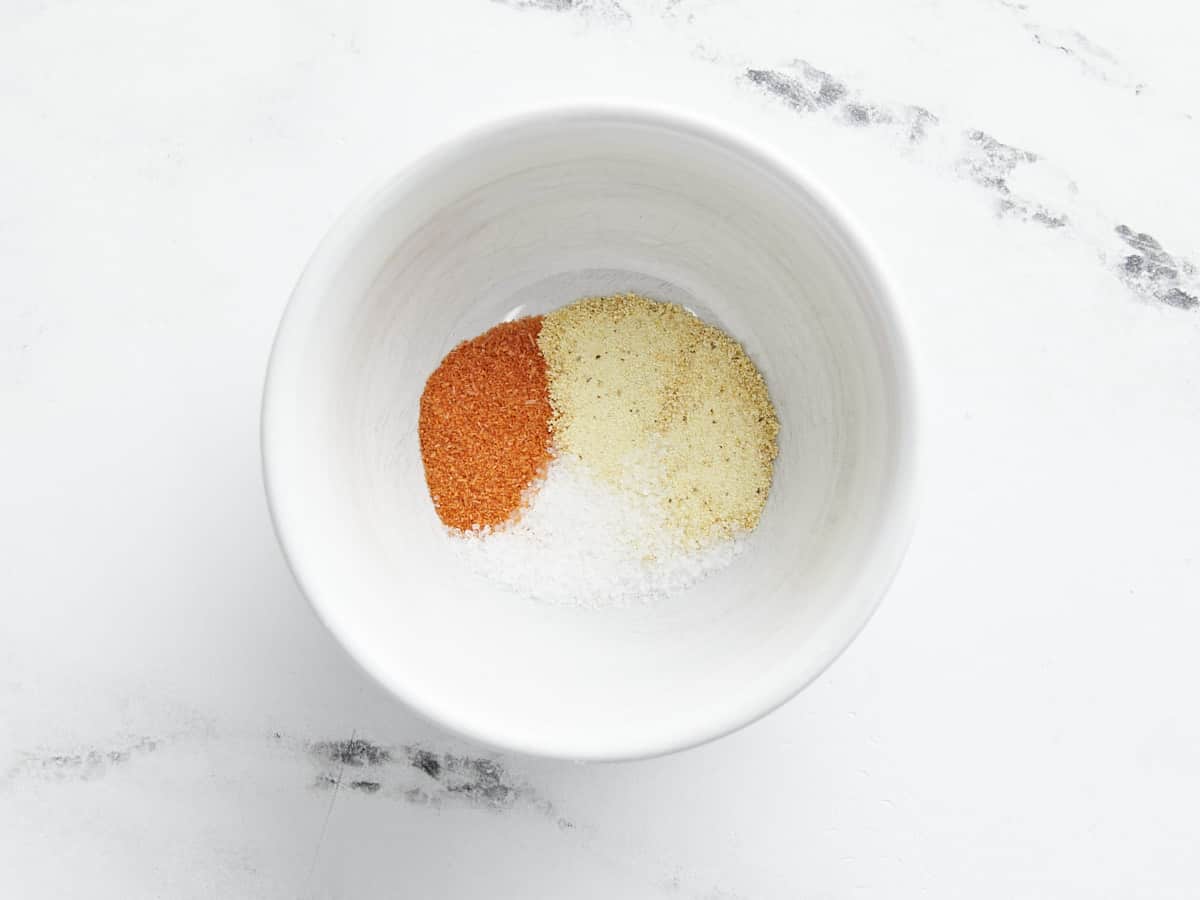 Overhead shot of spices to make Pinchos de Pollo in a white bowl.