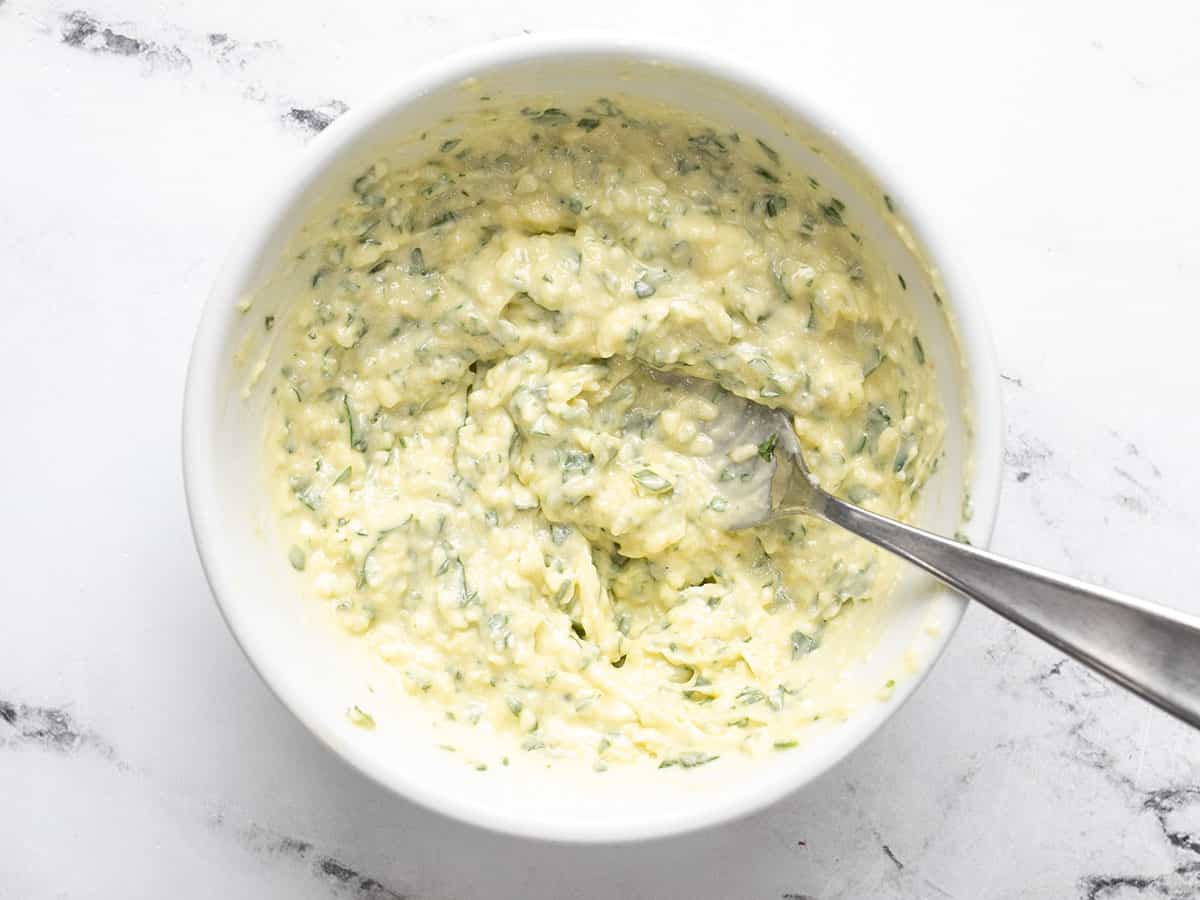 Mixed garlic butter in a bowl with a fork.