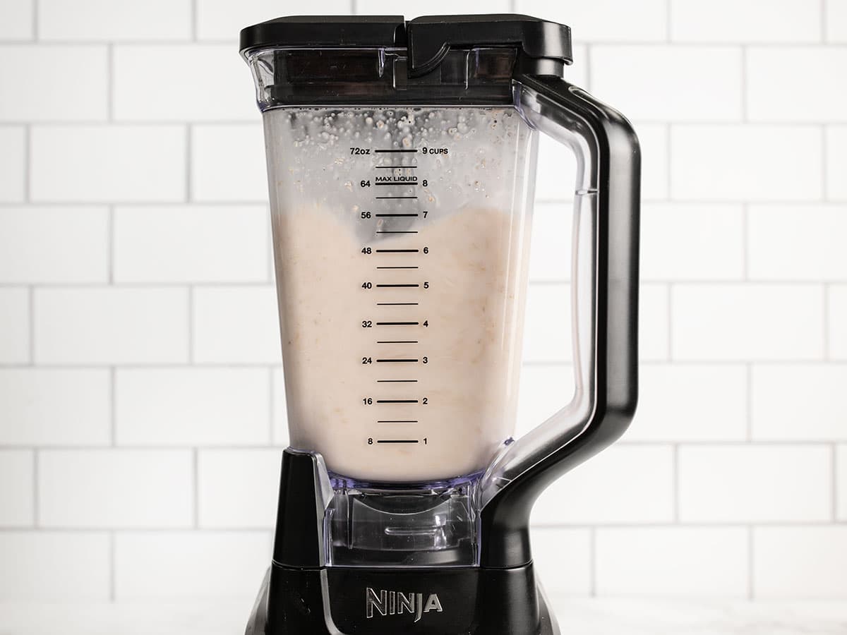 Oats and water being blended in a blender.