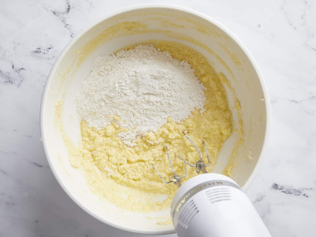 Wet and dry ingredients for lemon pound cake being mixed together.