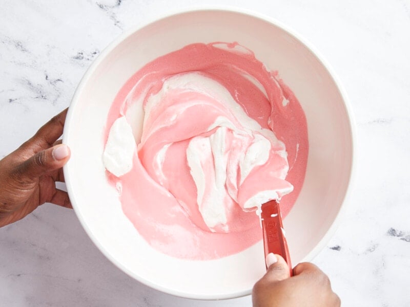 Strawberry gelatin mixture and whipped cream folded together.