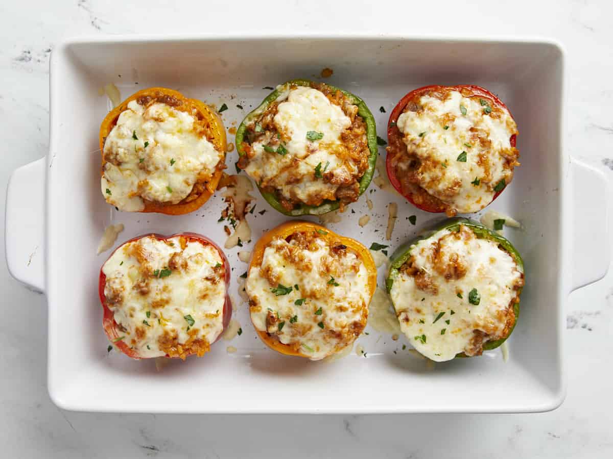 Overhead view of finished stuffed bell peppers in a casserole dish.