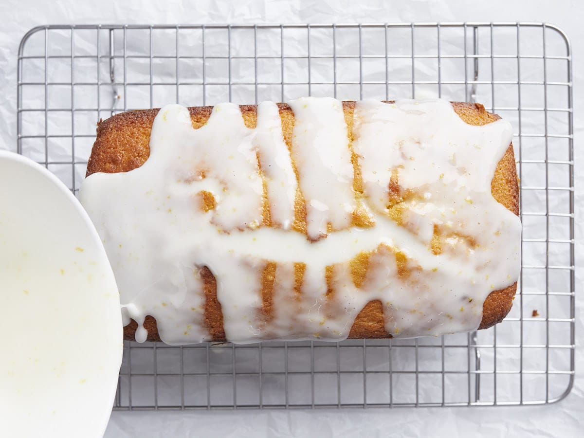 Glaze being poured over the pound cake. 