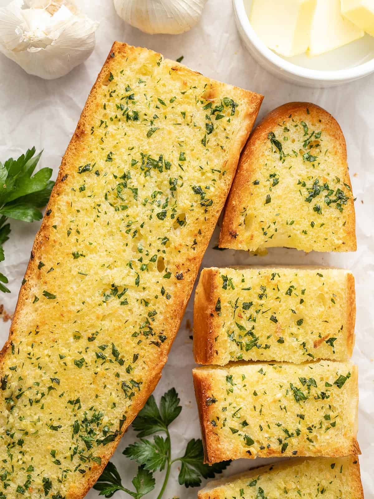 Two large pieces of garlic bread, one sliced into pieces.