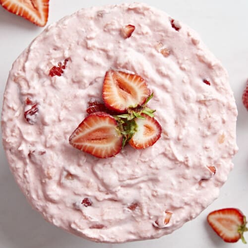 Overhead photo of a whole full of jello salad topped with sliced strawberries.