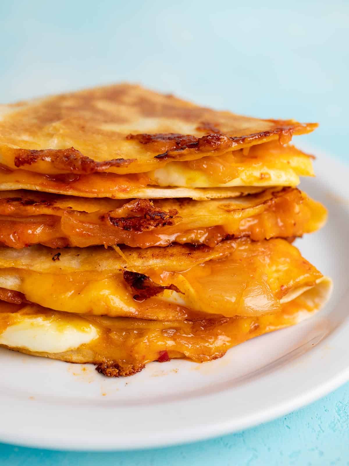 Close up side view of a stack of kimchi quesadillas.