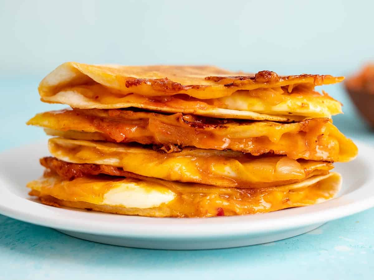 Side view of a stack of kimchi quesadillas on a plate.