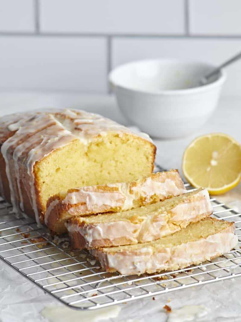 Front view of a loaf of lemon pound cake sliced on a cooling rack.