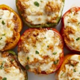 Overhead close up view of stuffed bell peppers on a serving plate.
