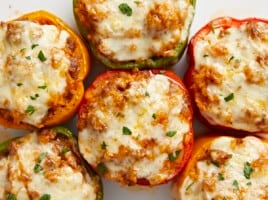 Overhead close up view of stuffed bell peppers on a serving plate.