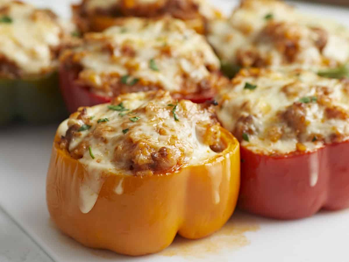 Close up side view of stuffed bell peppers on a serving plate.