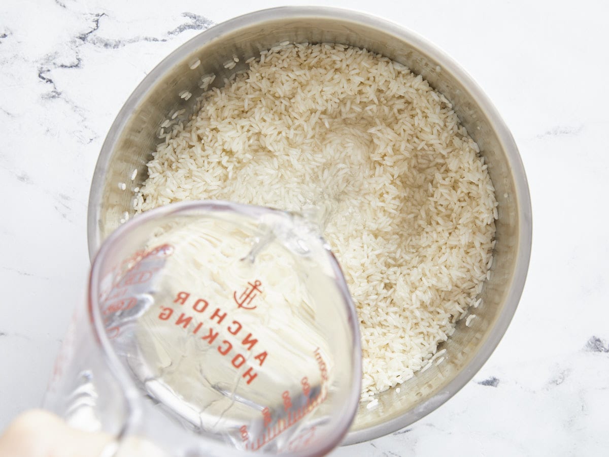 Boiling water being poured into a pot with rice. 