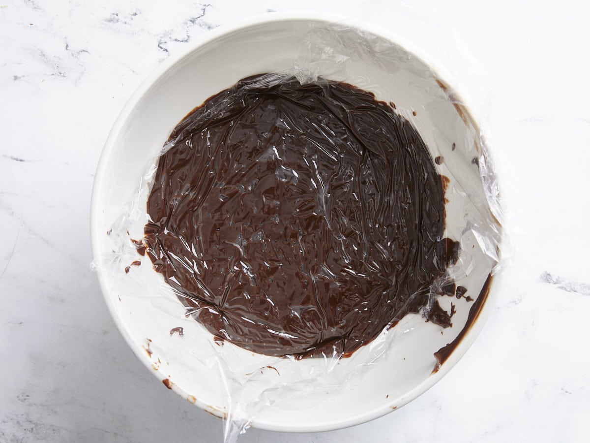 Chocolate in a bowl with plastic on top. 