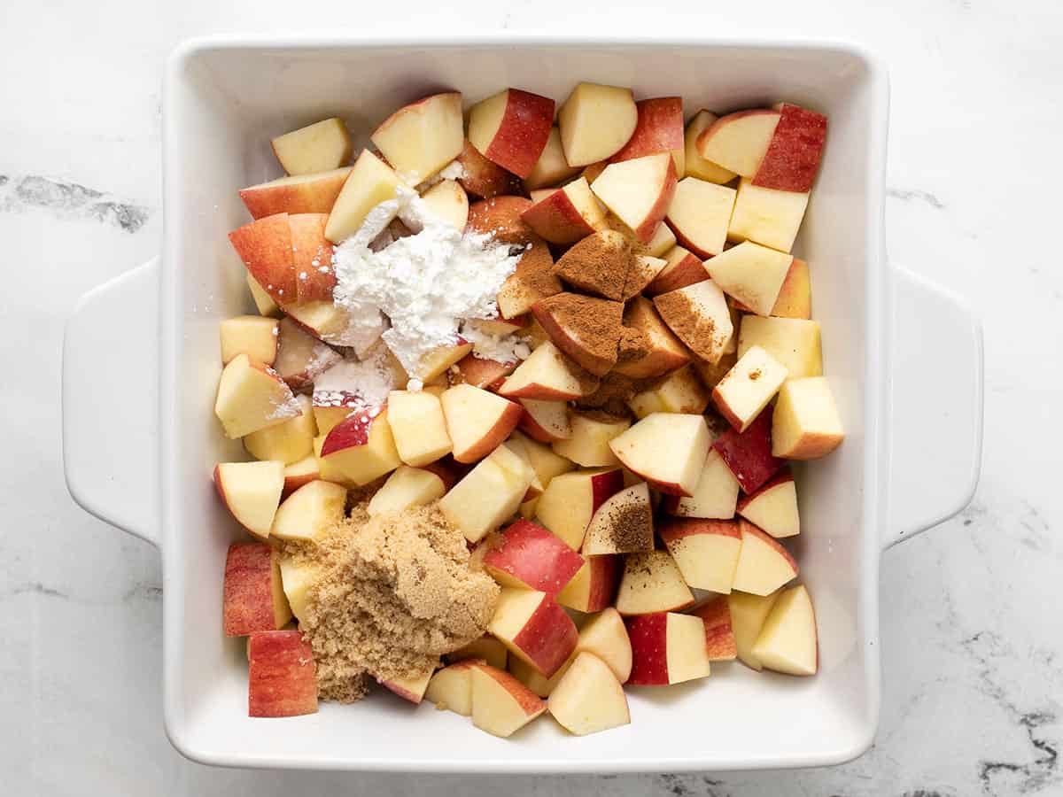 Apples in the casserole dish with sugar, spices, and cornstarch added.