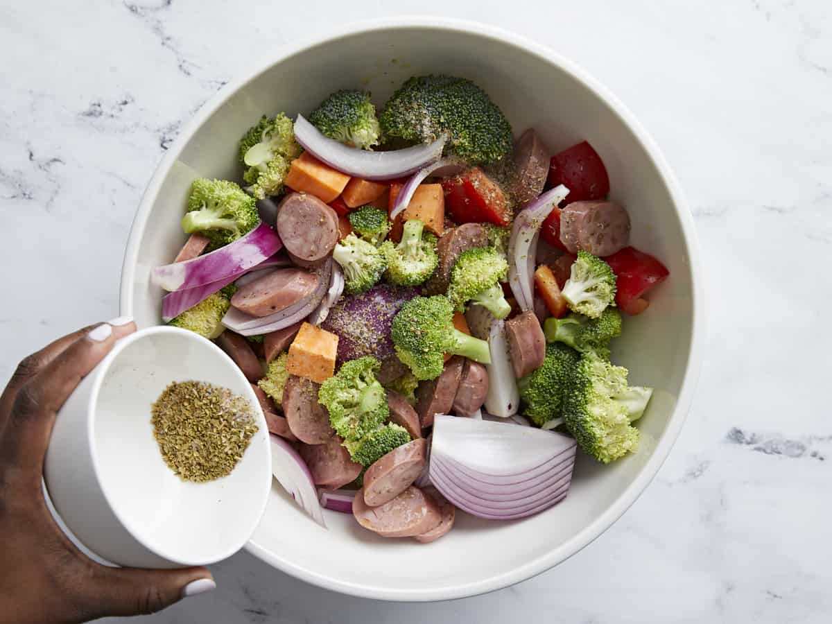 Chicken Sausage and Vegetables in a large bowl with oil and spices.