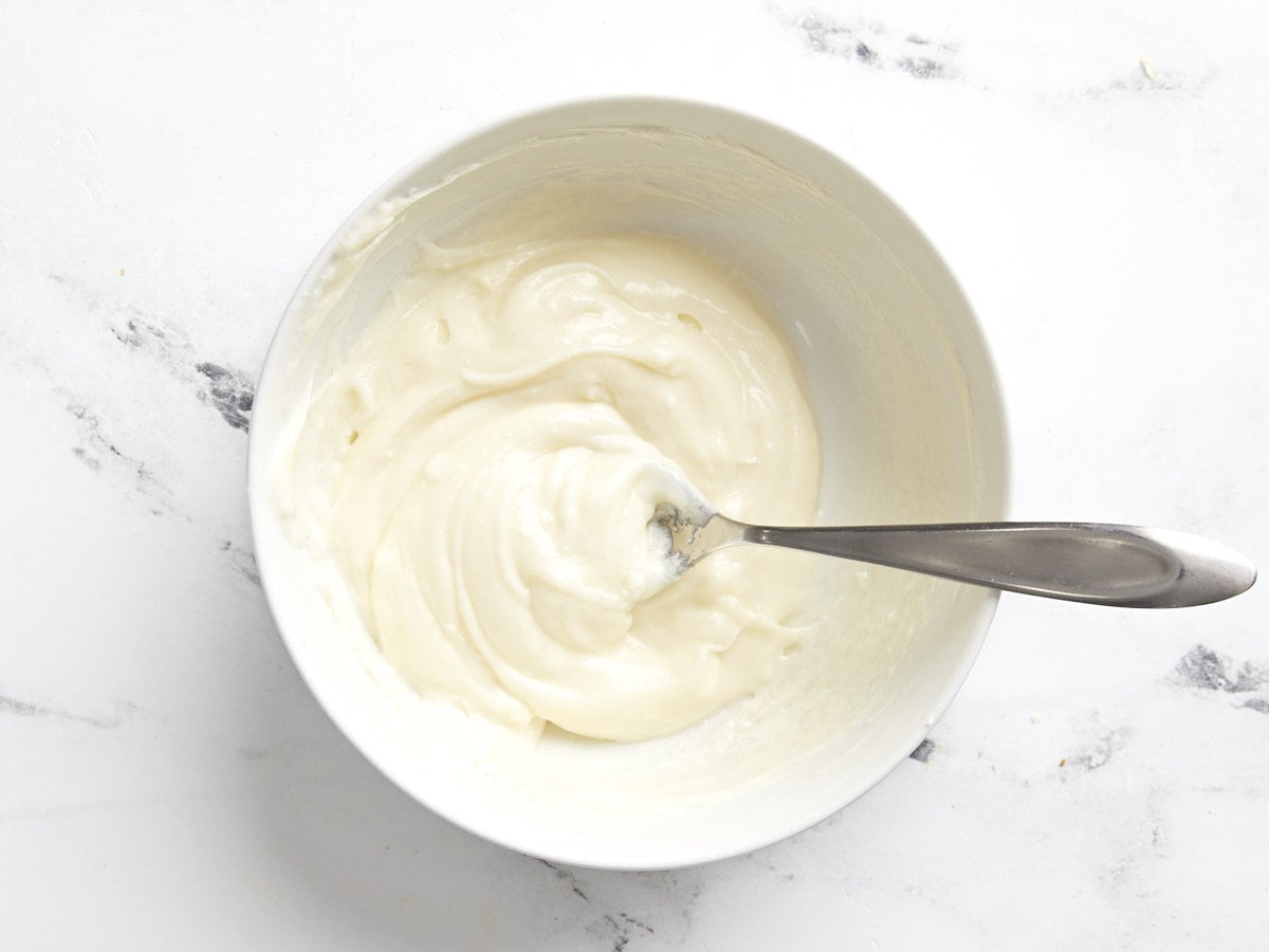 Cream cheese filling mixed in a bowl with a spoon.