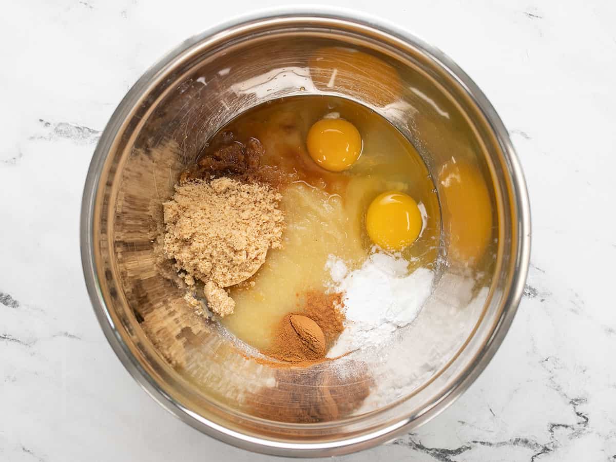Eggs, applesauce, sugar, and spices in a bowl.