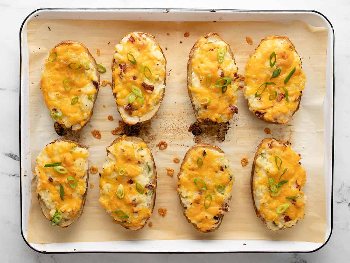 Finished twiced baked potatoes with green onions garnished on top.